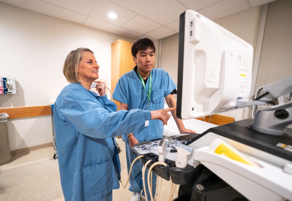 Doctor demonstrating a medical machine to an intern