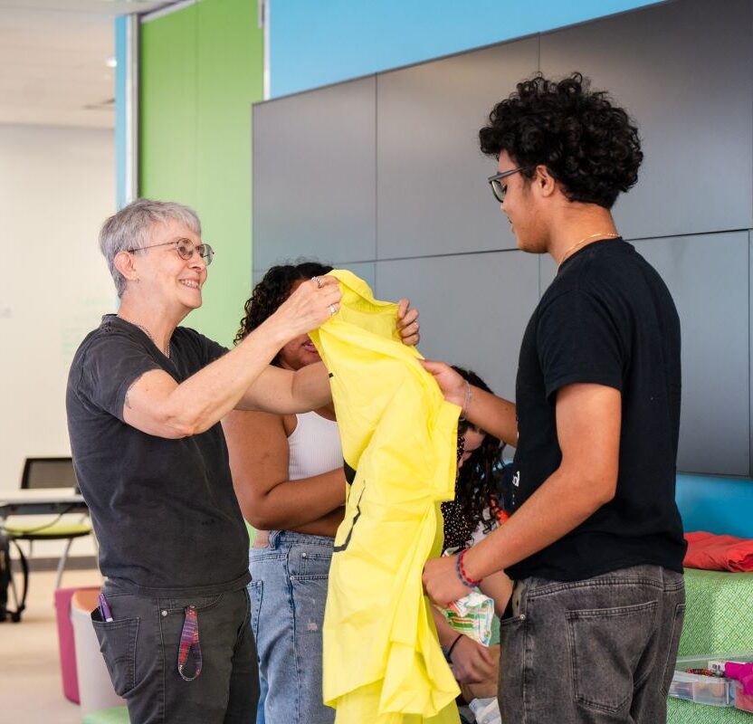 A high school student and a supervisor sifting through a pile of clothes