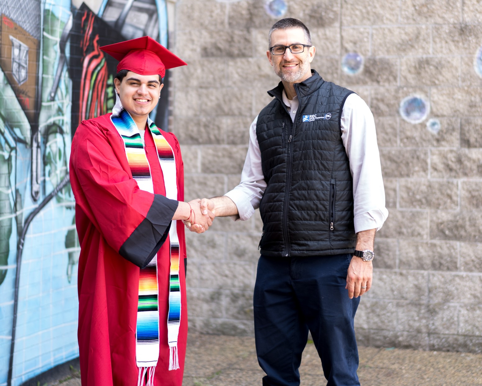 Joshua Baez in his cap and gown with REC Academic Support Instructor Seth Ford. 